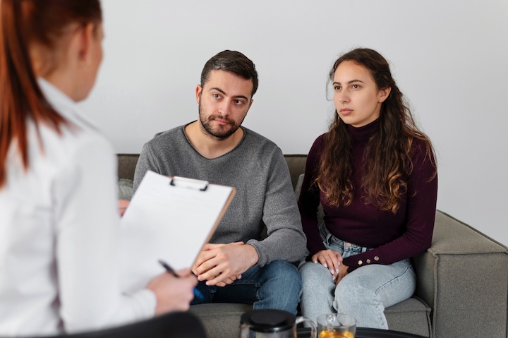 Familia recibiendo orientación profesional sobre las etapas del alcoholismo y las opciones de tratamiento.